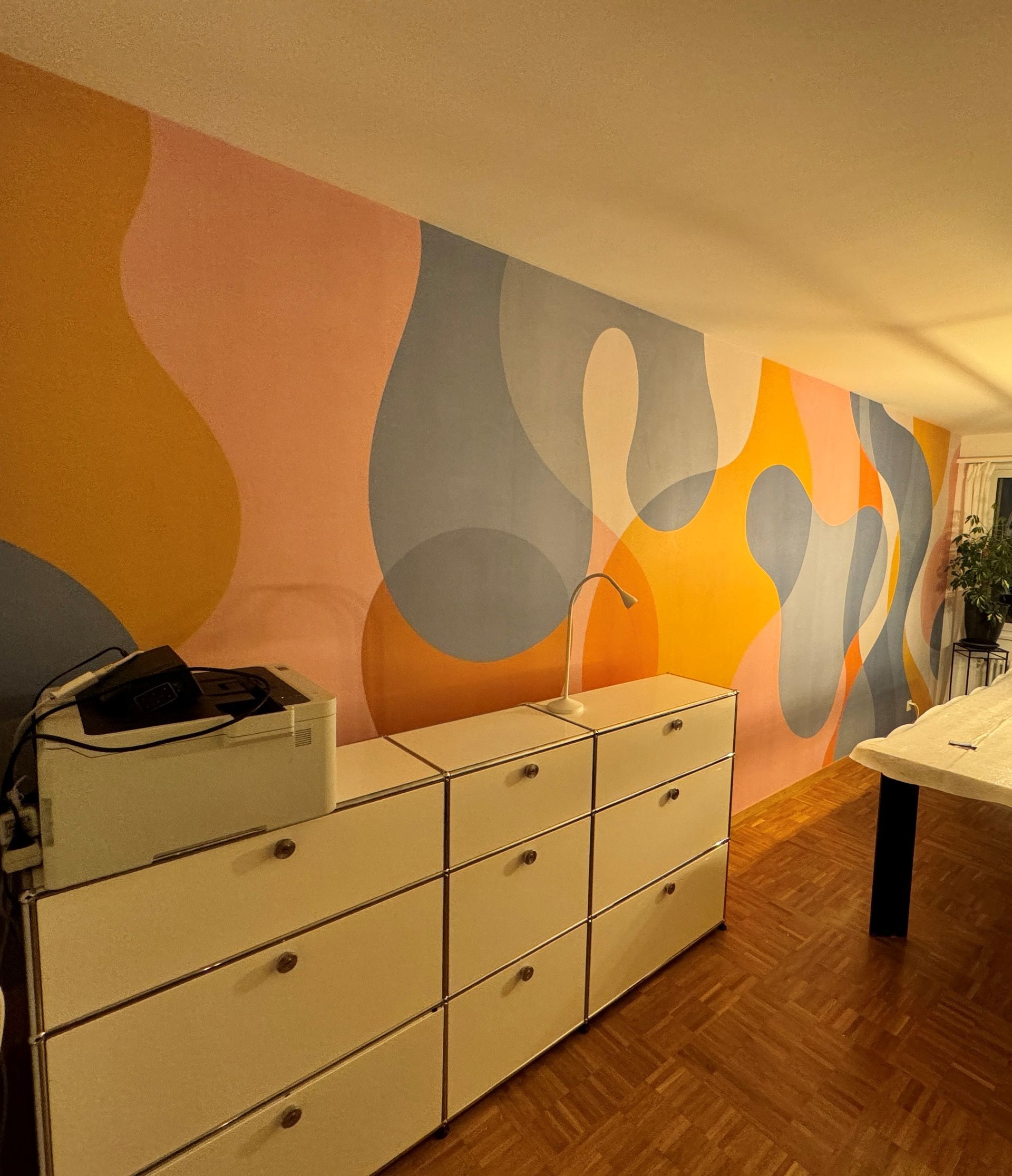 Ein Zimmer mit einem Gemälde an der Wand und einem Drucker auf einer Kommode