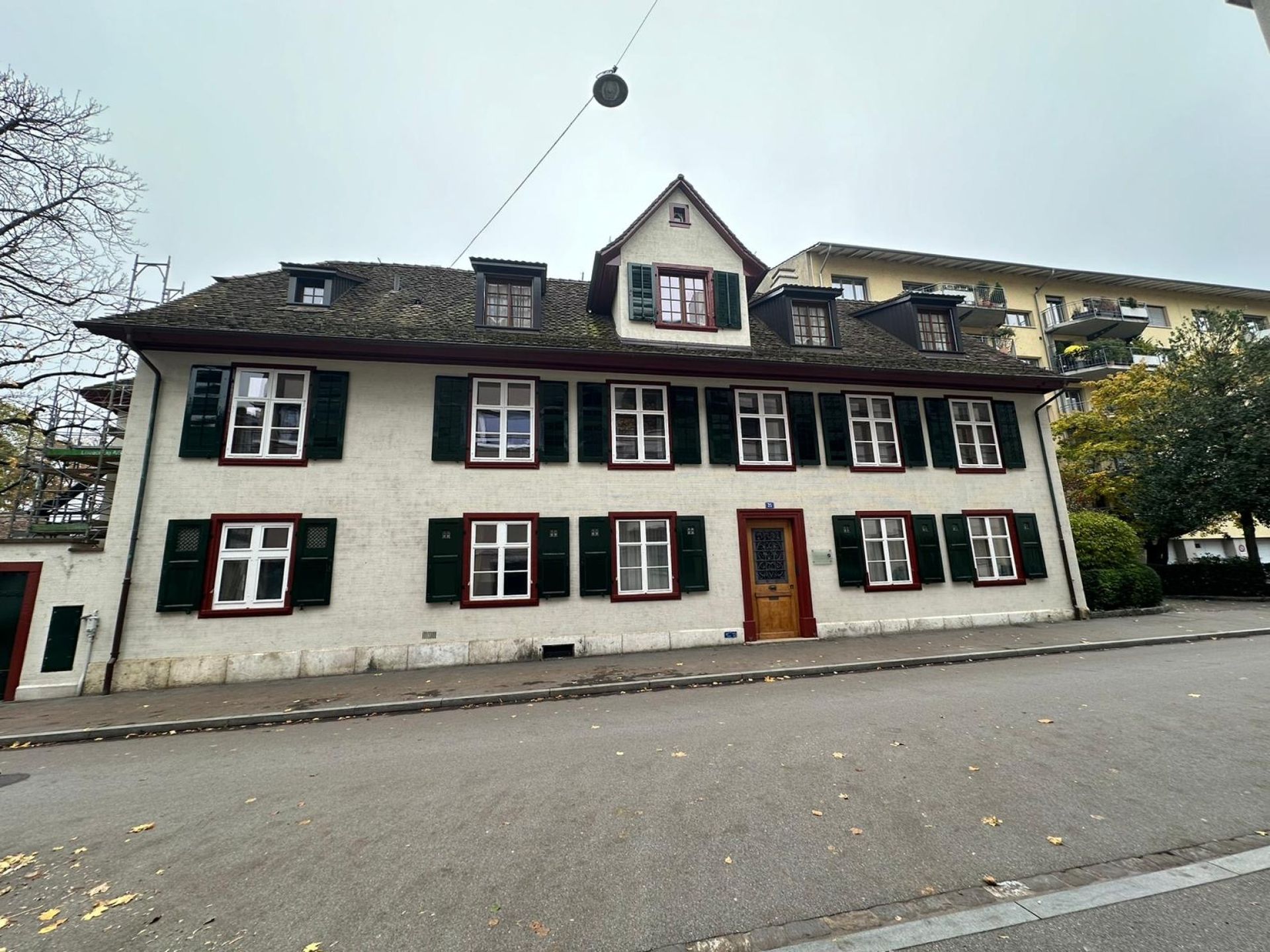 Ein großes weißes Gebäude mit schwarzen Fensterläden.