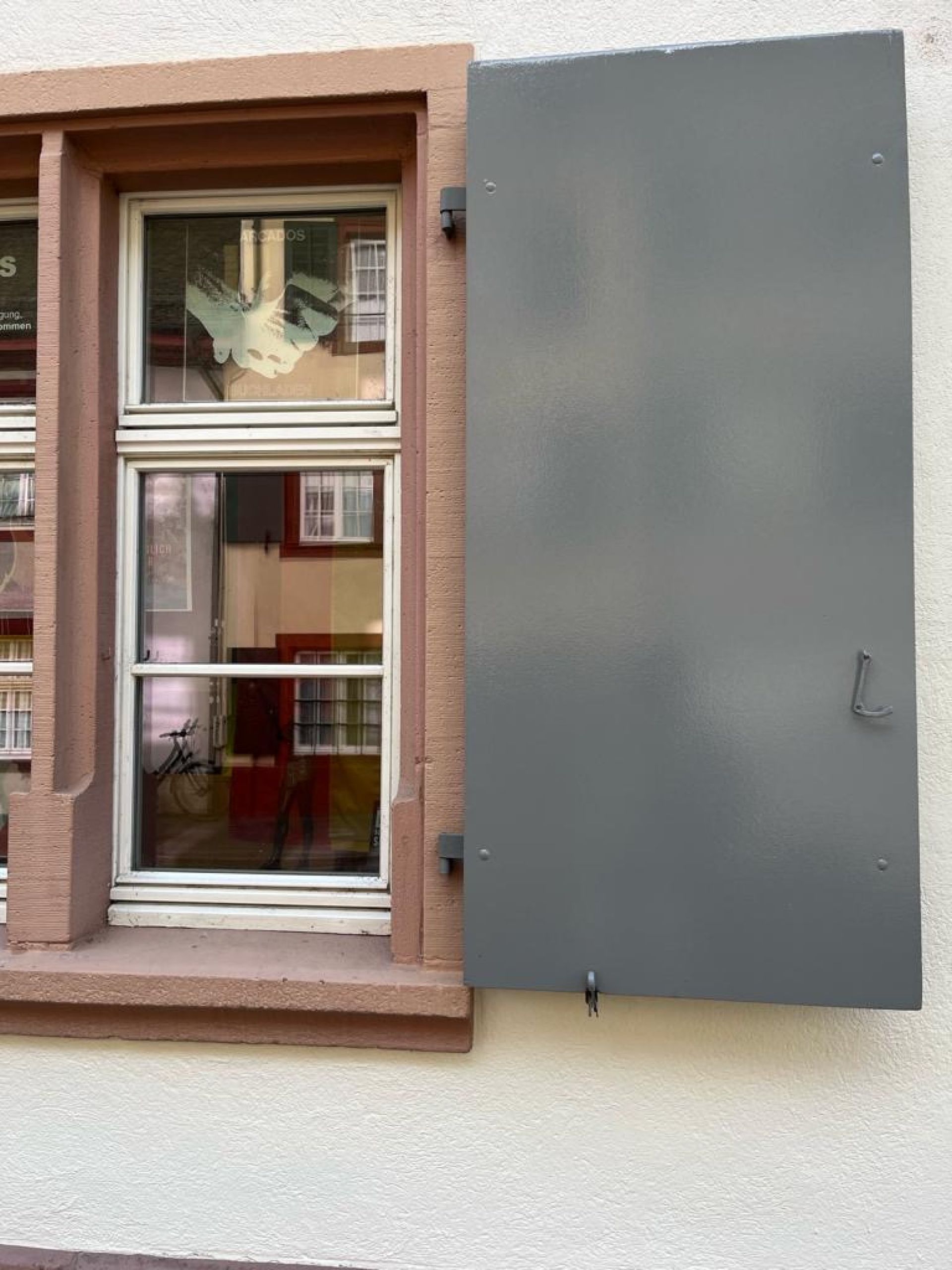 Ein Fenster mit einem grauen Fensterladen