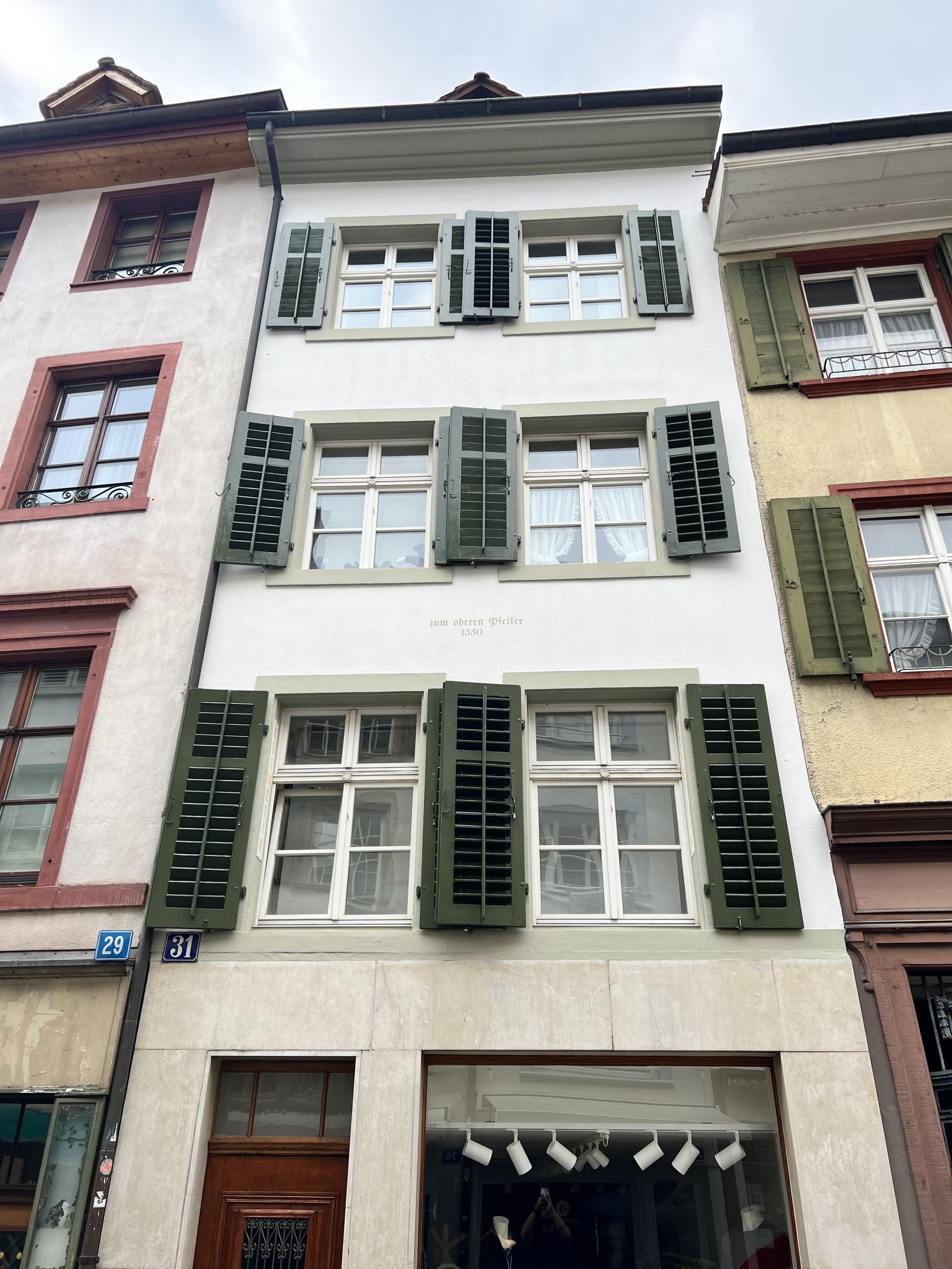 Ein Gebäude mit vielen Fenstern und grünen Fensterläden