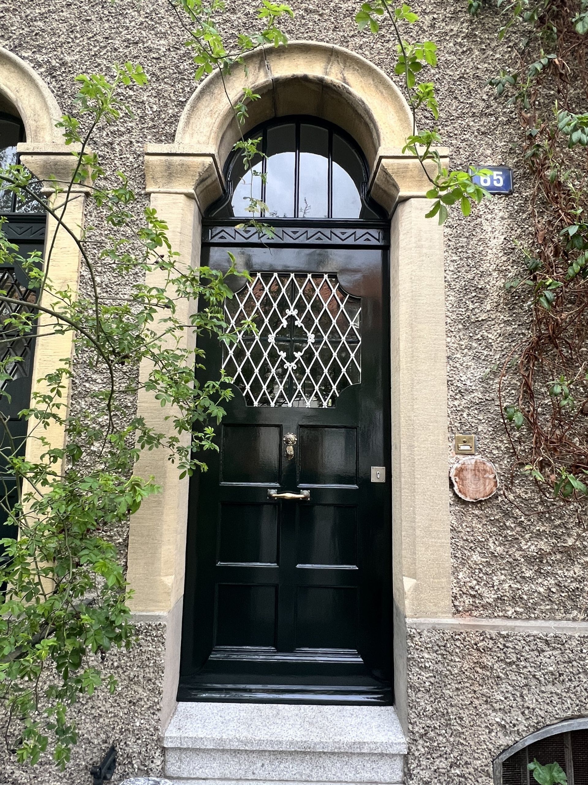 An der Vorderseite eines Steingebäudes befindet sich eine schwarze Tür.