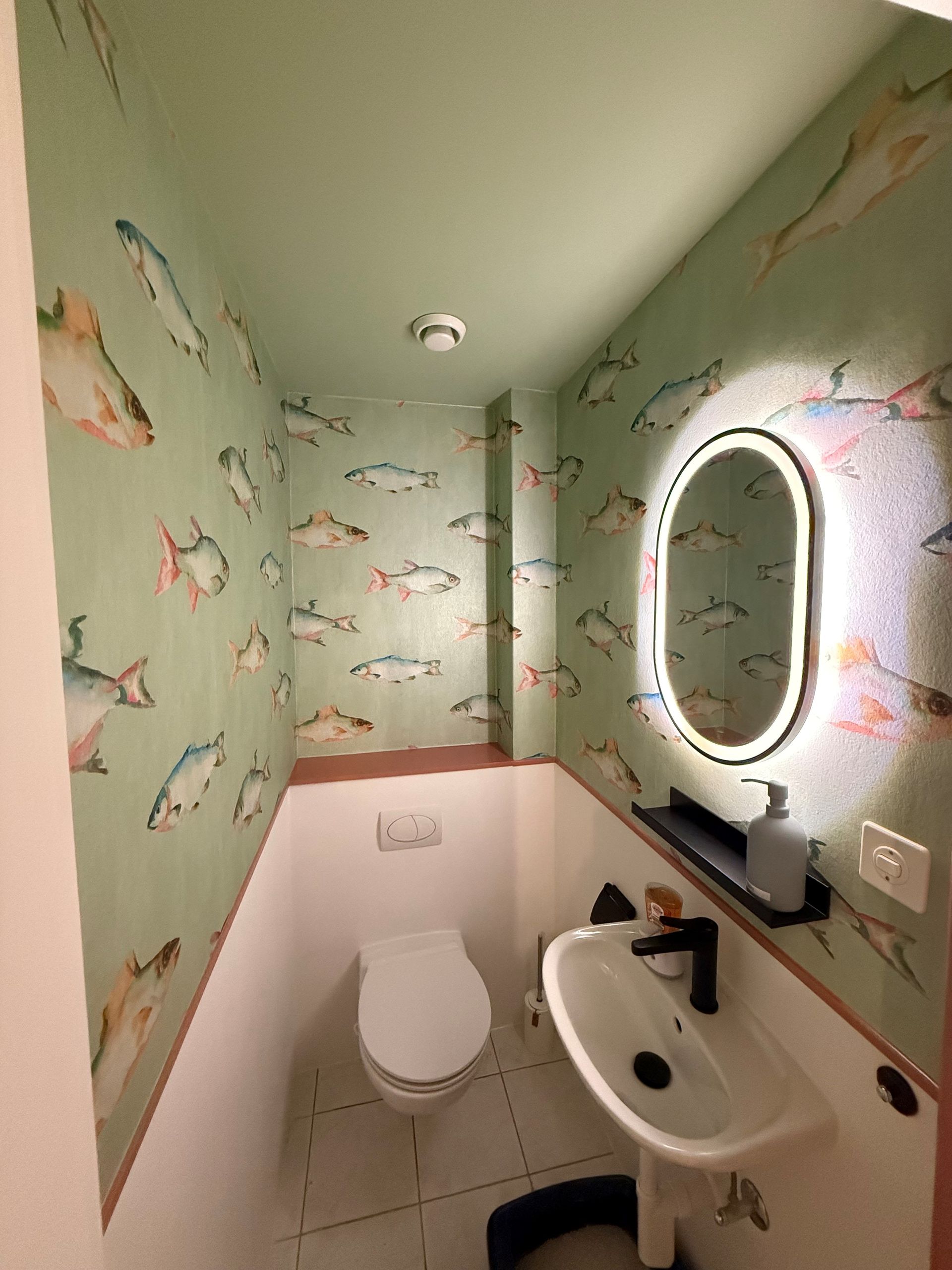 Ein Badezimmer mit Toilette, Waschbecken und Spiegel.