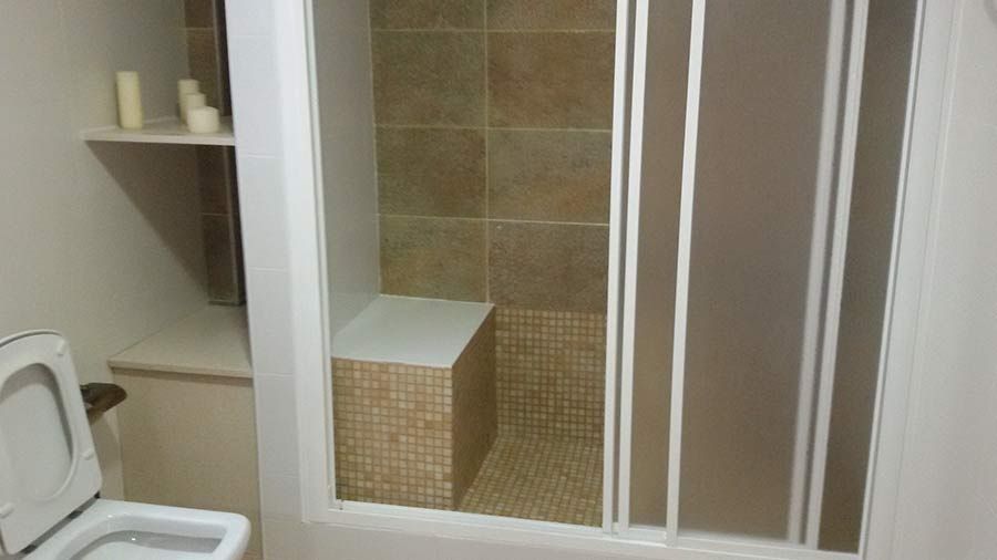 Un baño con inodoro y cabina de ducha.