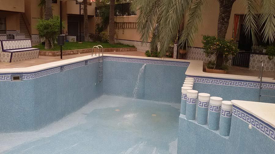 Una piscina vacía con una cascada en el medio.