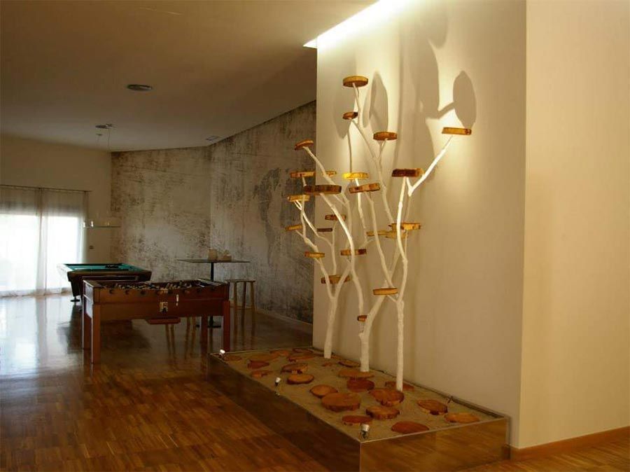 Una habitación con una mesa de billar y una escultura en la pared.