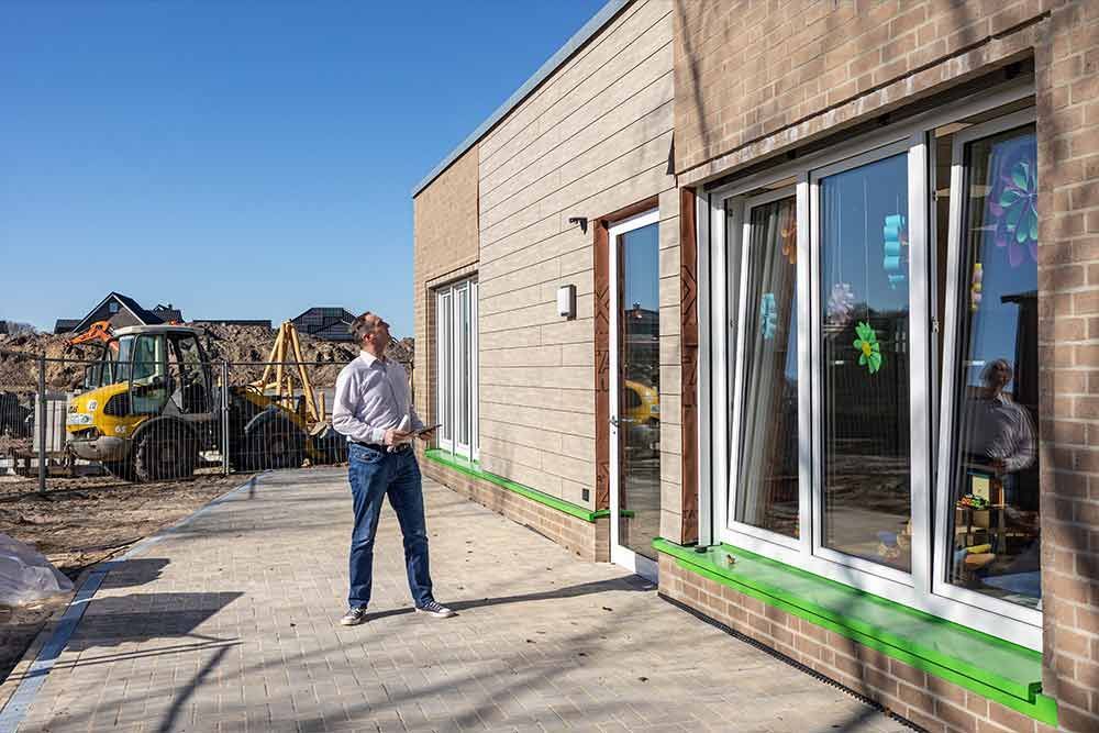 Ein Mann steht vor einem im Bau befindlichen Gebäude.