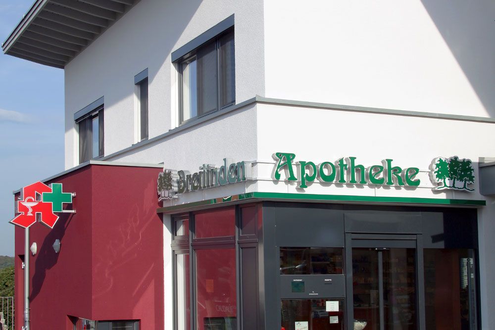 Ein Gebäude mit einem grünen Schild mit der Aufschrift „Apotheke“