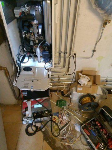 Nahaufnahme eines kleinen Motors oder einer Pumpe mit Schläuchen und Kabeln in einer Werkstattumgebung