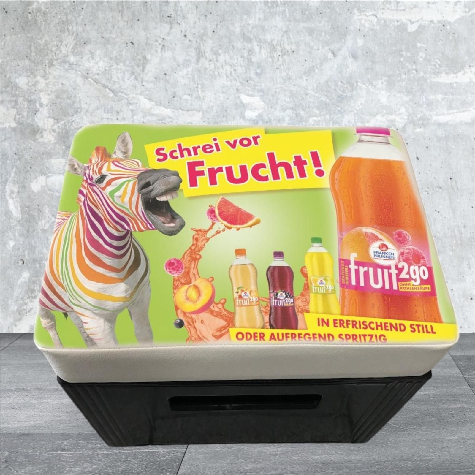 Display mit buntem Zebra und Fruchtsaftflaschen, Slogan „Scream for Fruit!“.