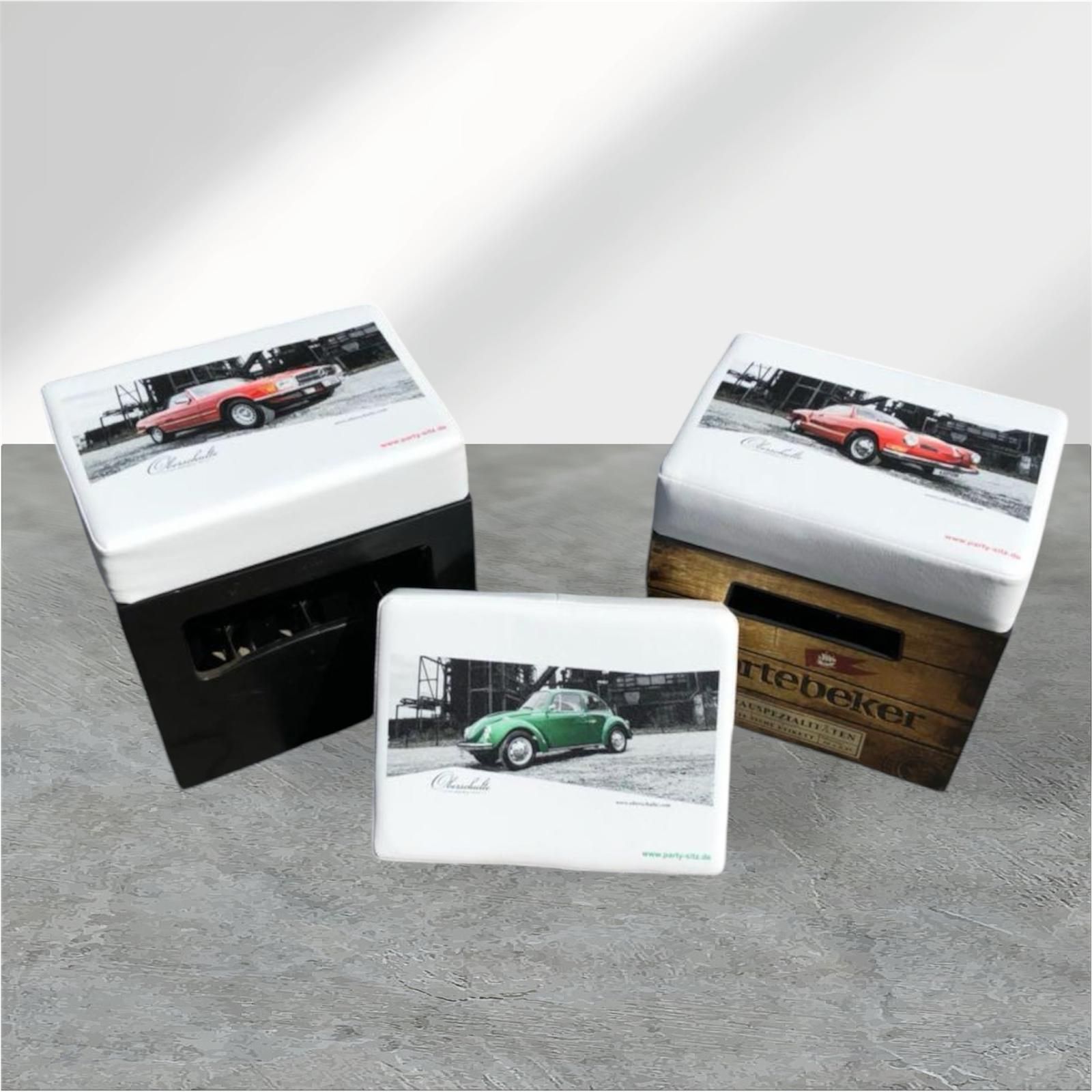 Drei Schachteln mit weißem Deckel und Bildern klassischer Autos auf der Oberseite, jede mit einem anderen Design; eine in Schwarz, eine in Holzoptik und eine kleine.