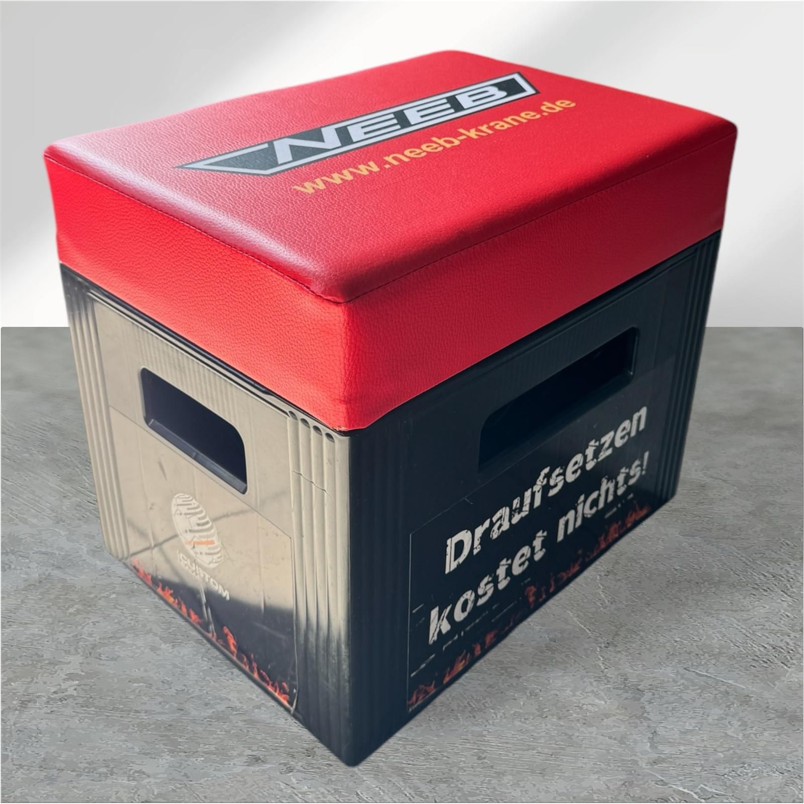 Schwarz-rote Aufbewahrungskiste mit gepolstertem Deckel, mit Text und Logo versehen.