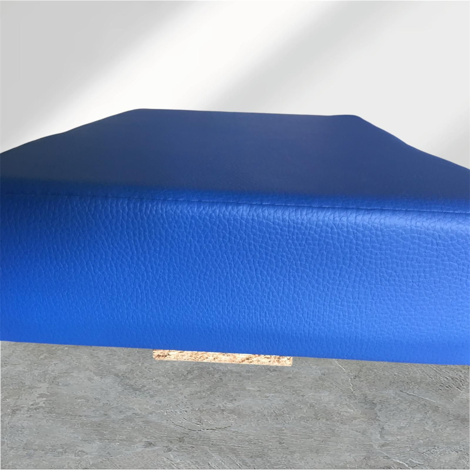 Blaues gepolstertes Sitzkissen auf grauem Untergrund.