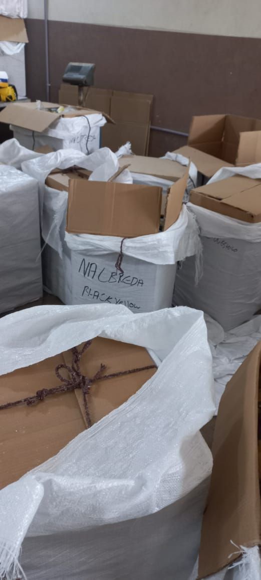 Kisten und Säcke in einem Lagerhaus, einige sind mit Papier umwickelt.