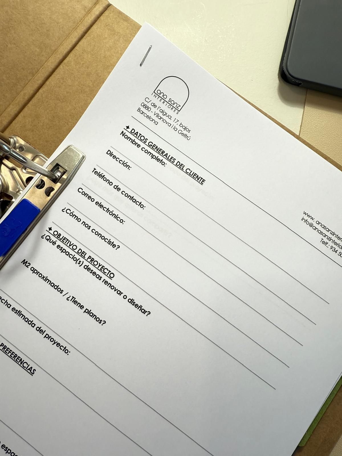 Agenda o cuaderno abierto con una página rayada y un lápiz, junto a una caja de madera y una barandilla negra.