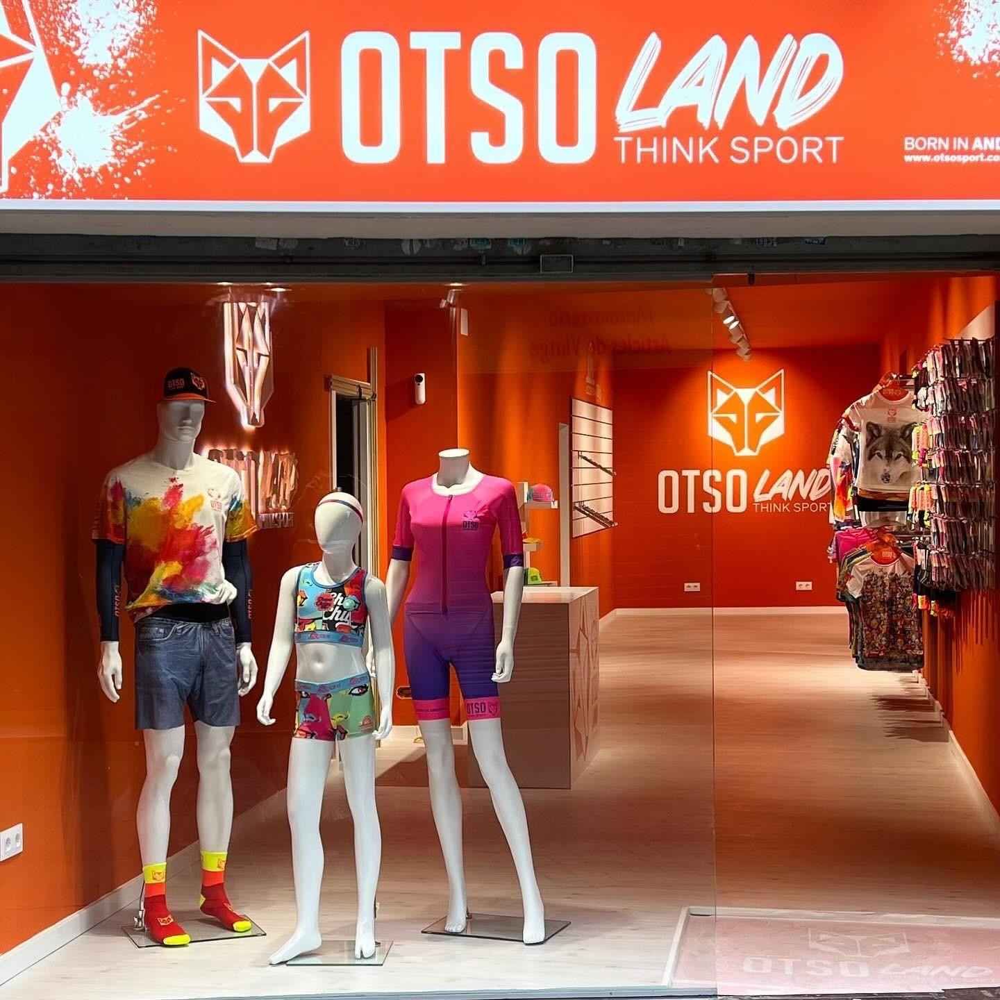 Entrada de la tienda de ropa deportiva OTSO Land con maniquíes vestidos con coloridos atuendos deportivos.