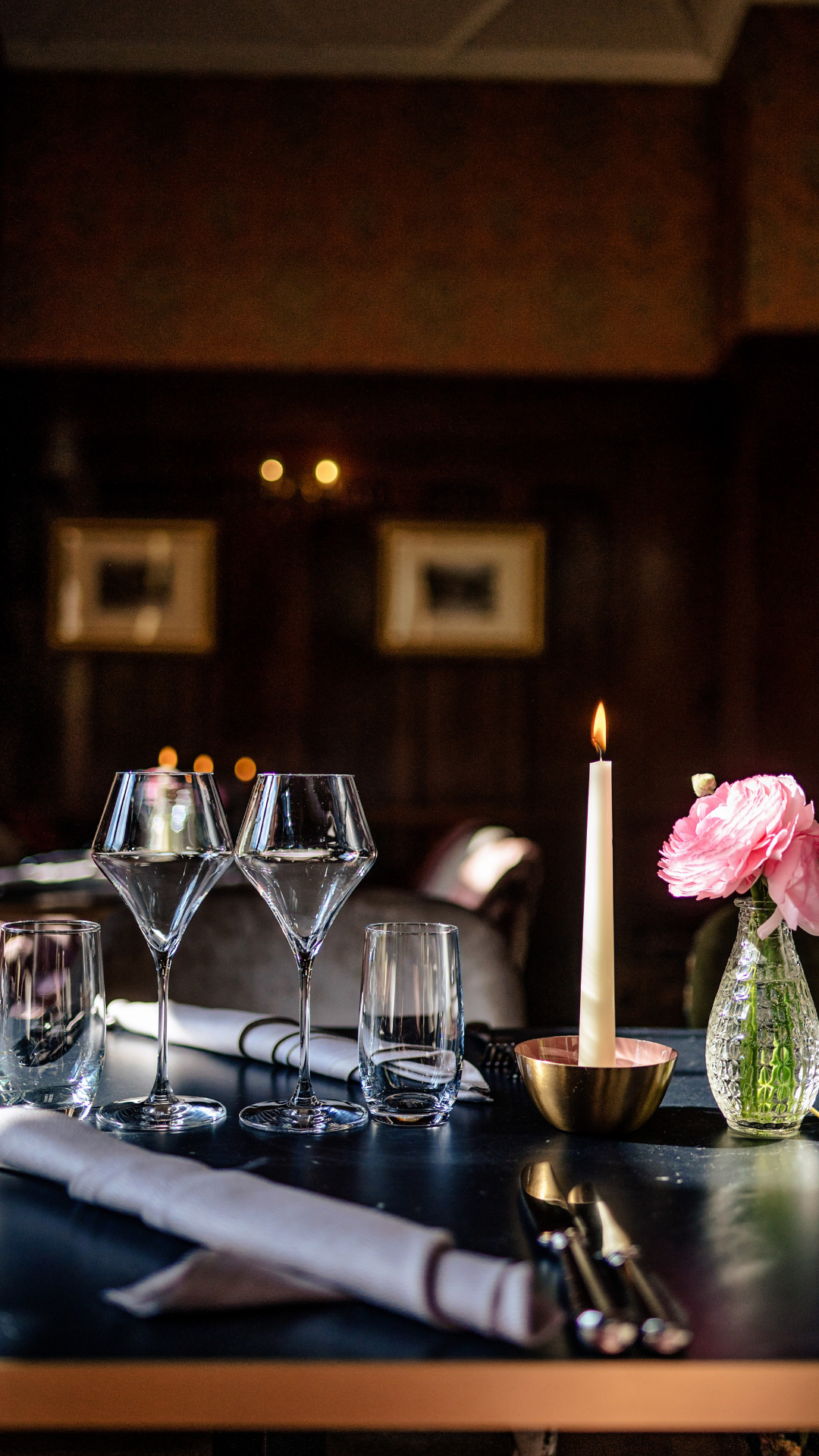Een bakstenen gebouw met een gestreepte luifel boven een met klimop begroeid terras.