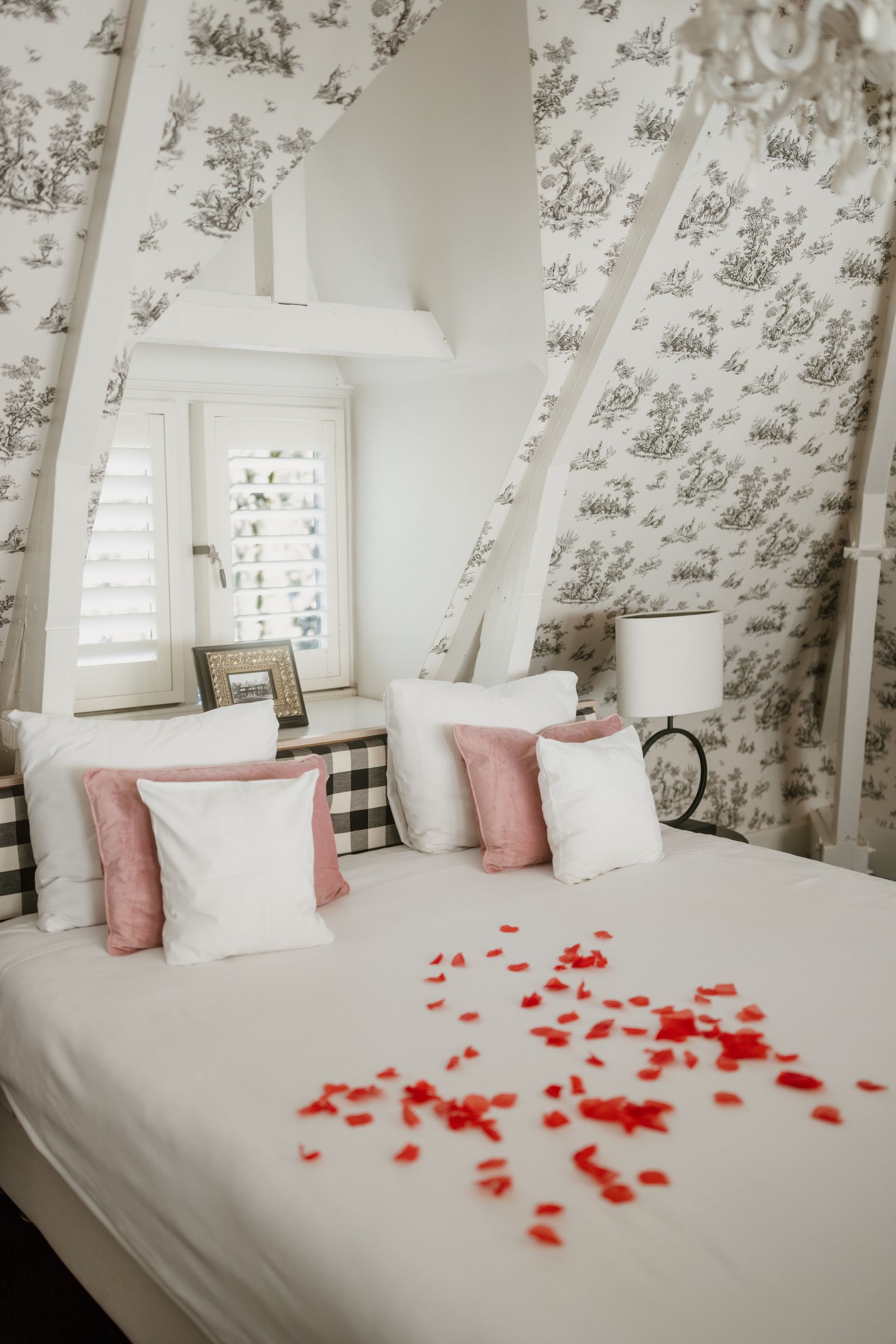 Elegante eettafel gedekt voor een maaltijd, in een kamer met donkerhouten lambrisering en bloemendecoraties.