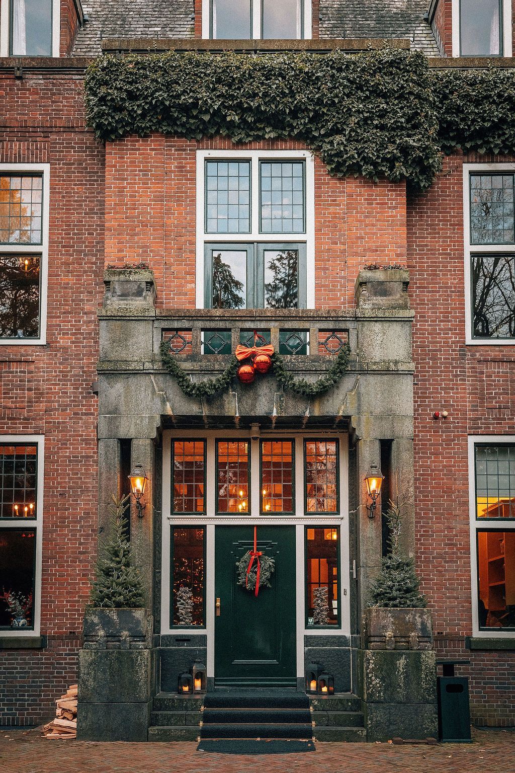 Een bord met bloemenmotief, een klein gelaagd dessert en een aardbei op een etagère met gebak op de achtergrond.