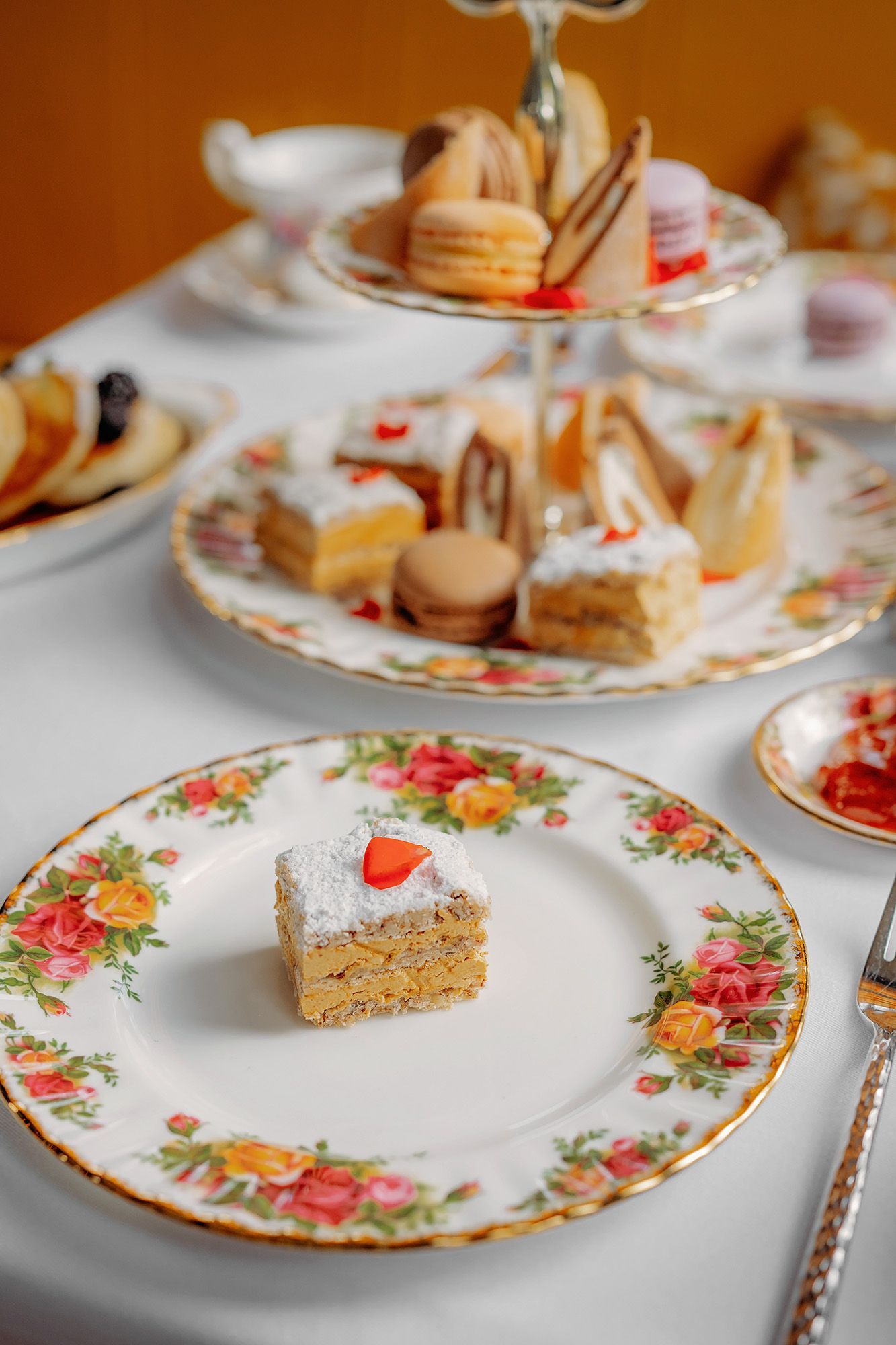Met klimop begroeid bakstenen gebouw met een gele luifel en een terras.