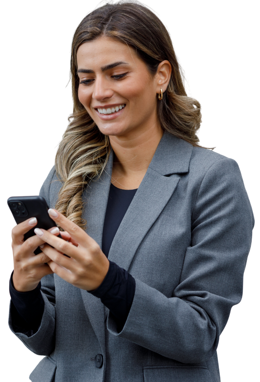 Une femme en tailleur gris sourit en regardant un Smartphone.