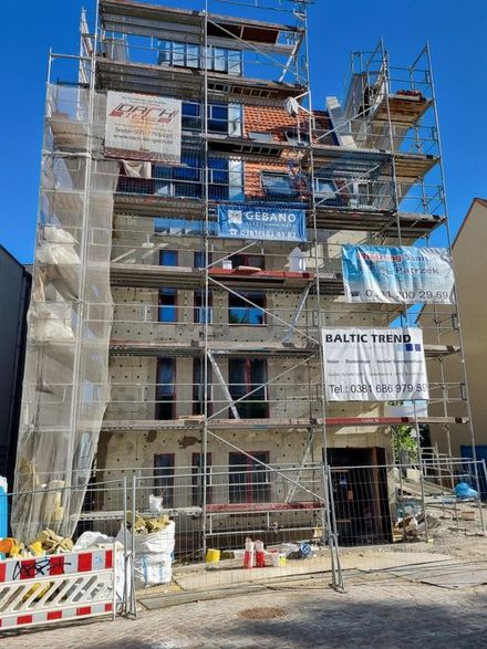 Am Straßenrand wird ein großes Gebäude errichtet.
