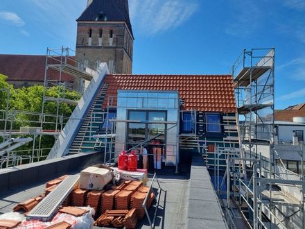 Am Straßenrand wird ein großes Gebäude errichtet.