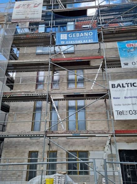 Am Straßenrand wird ein großes Gebäude errichtet.