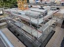 Am Straßenrand wird ein großes Gebäude errichtet.