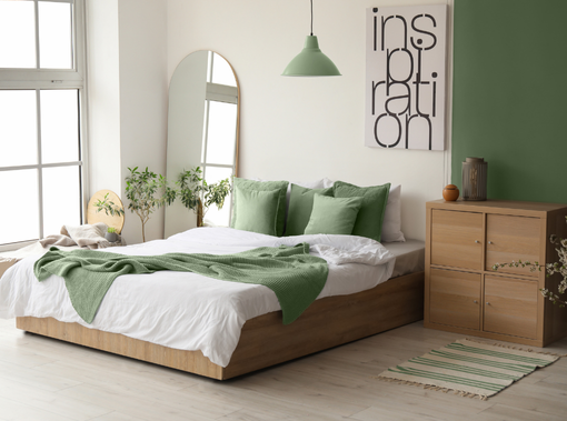 Chambre avec un mur bleu, un lit, deux fenêtres, un plancher en bois et une petite étagère.