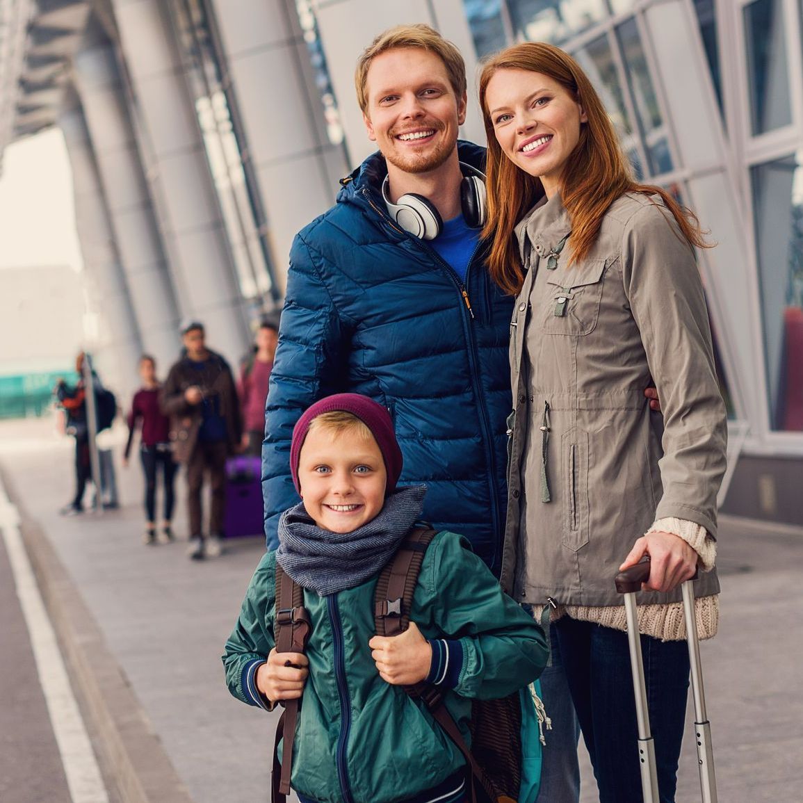 Une famille souriante qui attend un taxi à la gare