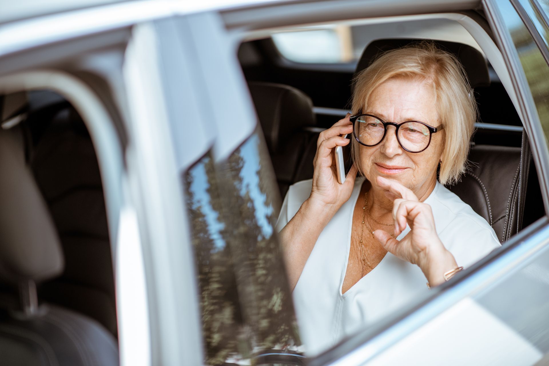 Personne âgée au téléphone dans un taxi