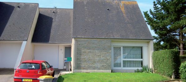 Maison de cité avec une voiture rouge garée devant