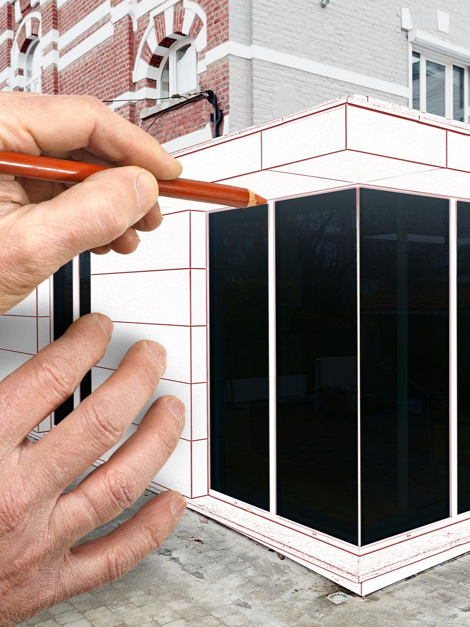 Des mains utilisent un crayon pour dessiner la façade d'un bâtiment sur du papier.