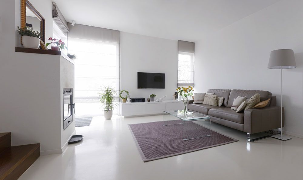 Modernes Wohnzimmer mit weißen Wänden, braunem Sofa und Fernseher.