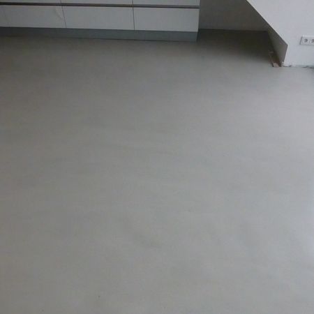 Hellgrauer Boden, im Hintergrund Schränke und Wand.