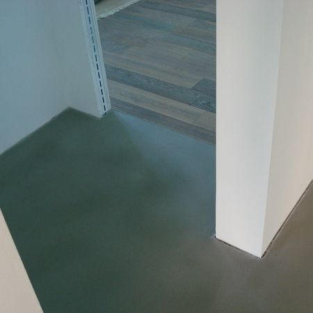 Grauer Boden im Türrahmen, im Hintergrund weiße Wände und Holzboden.