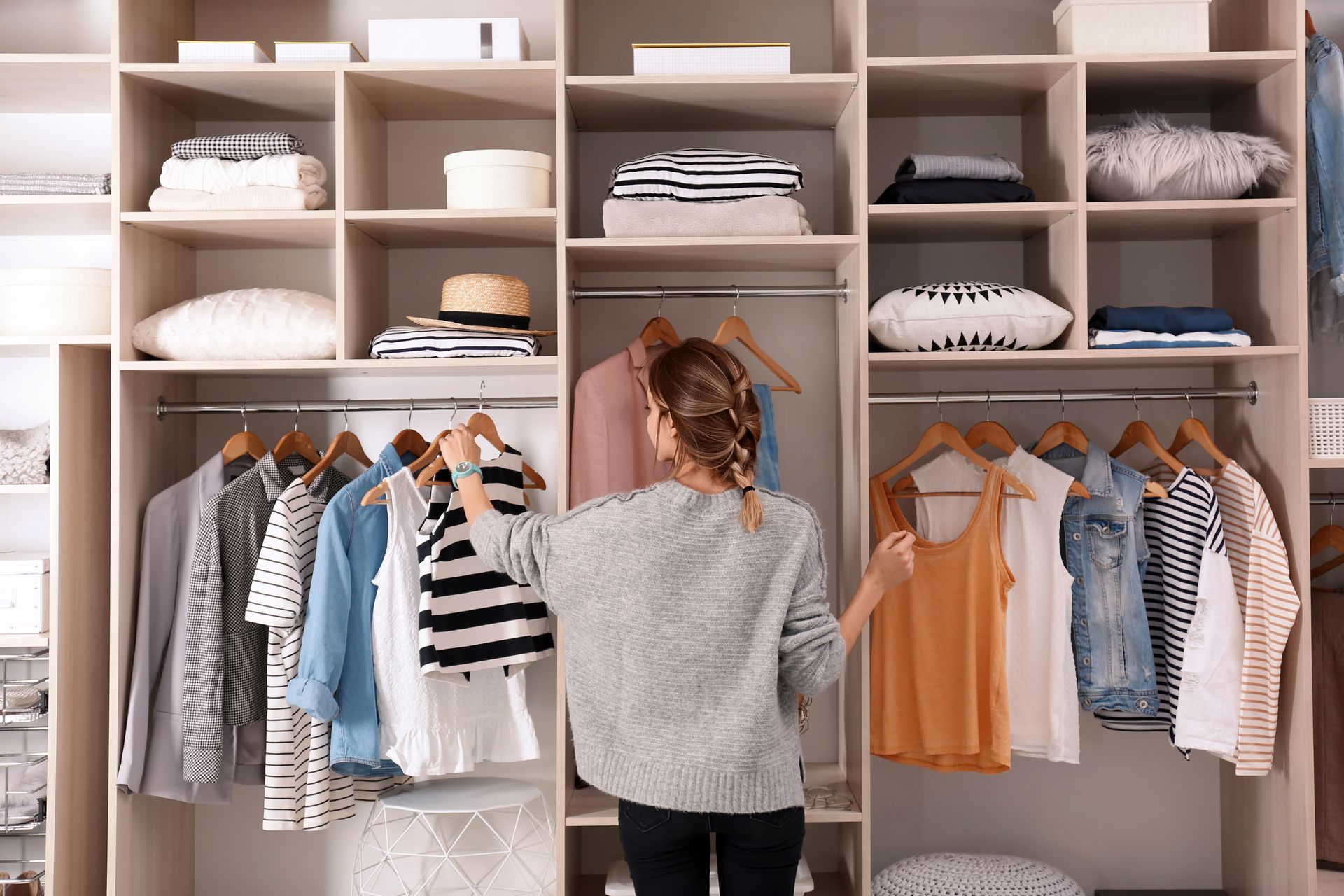 Jeune femme en train de choisir ses vêtements dans son dressing