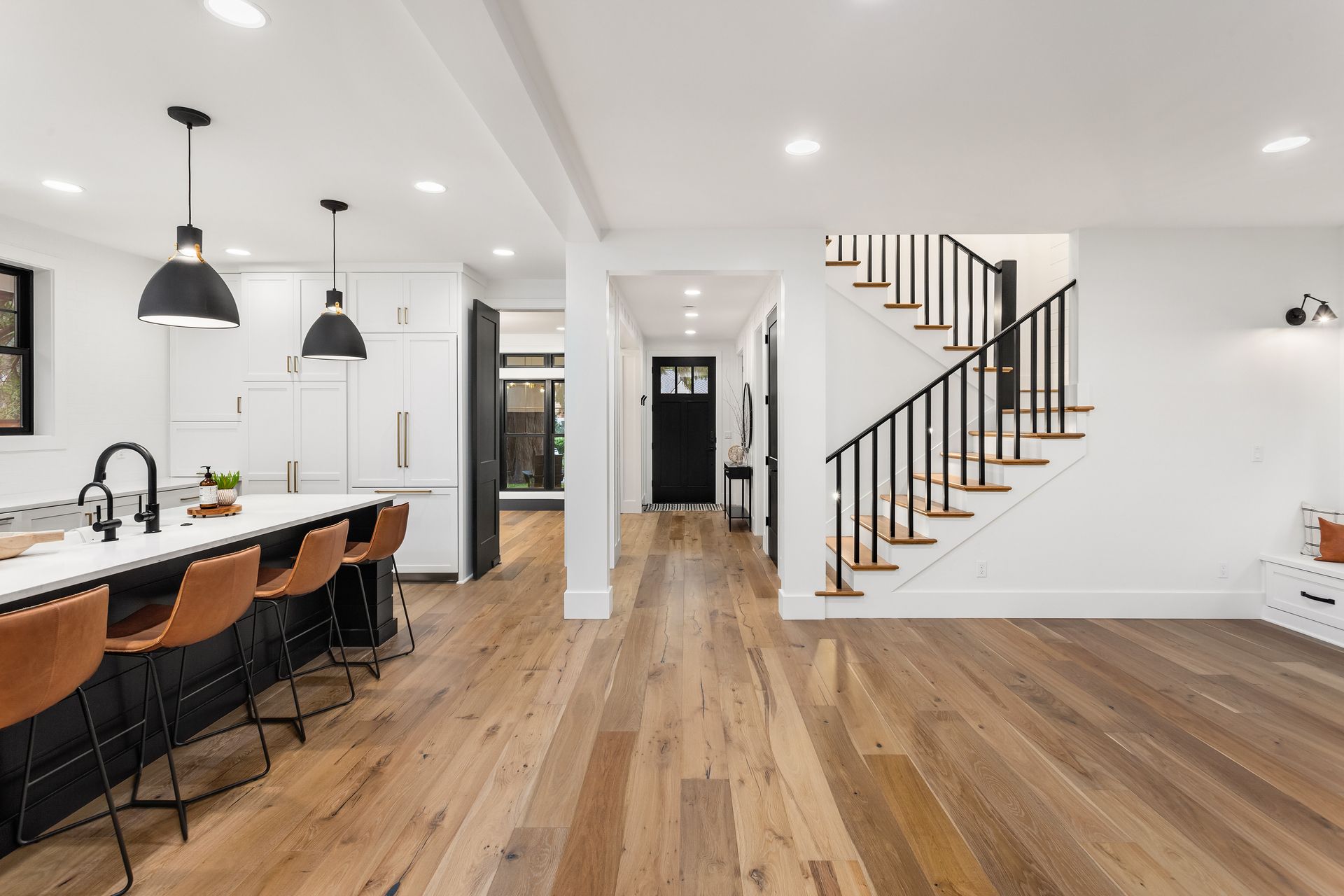 Escalier blanc dans une grande pièce au sol en parquet