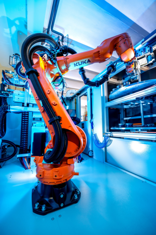 Ein Roboterarm steht in einem Fabrikraum.