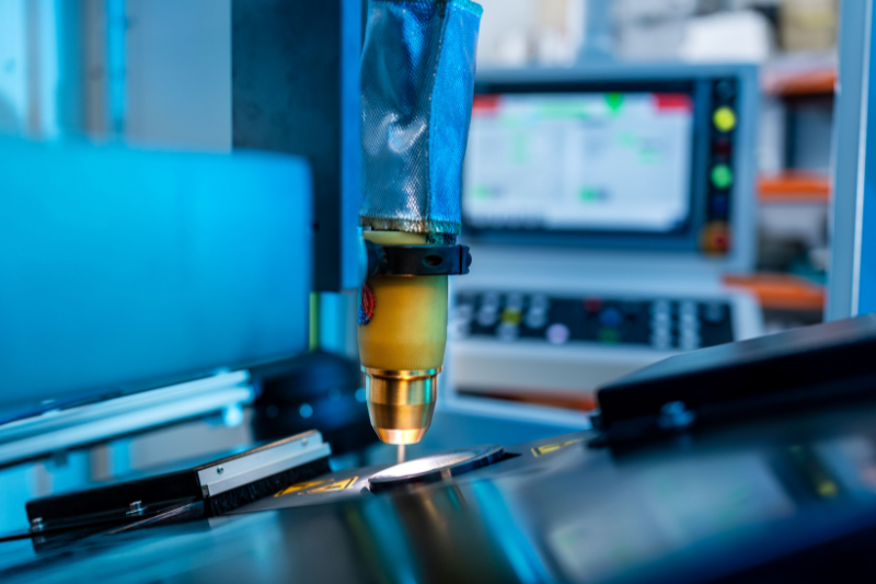 In einer Fabrik schneidet eine Maschine ein Stück Metall.