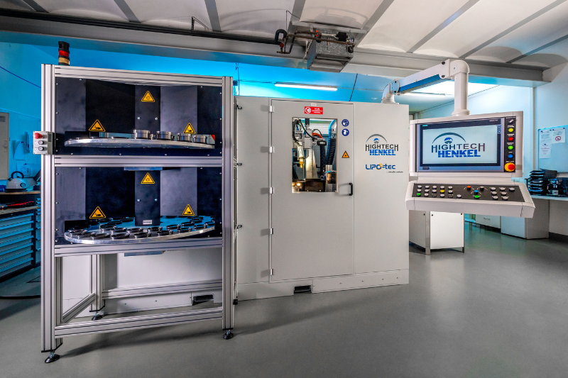 In einem Raum steht eine Maschine neben einem Computermonitor.