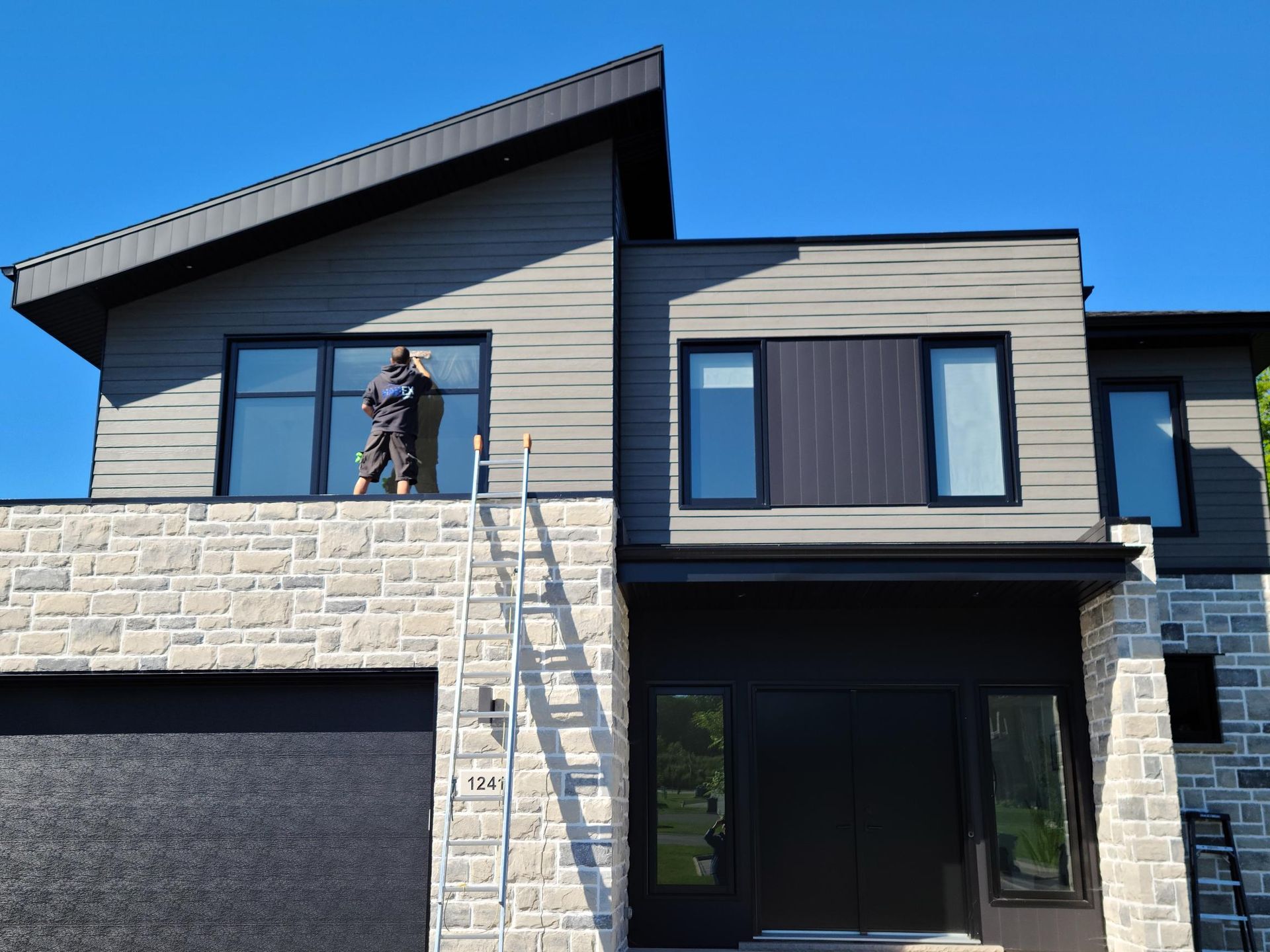 Nettoyage de vitres en hauteur d'une maison moderne