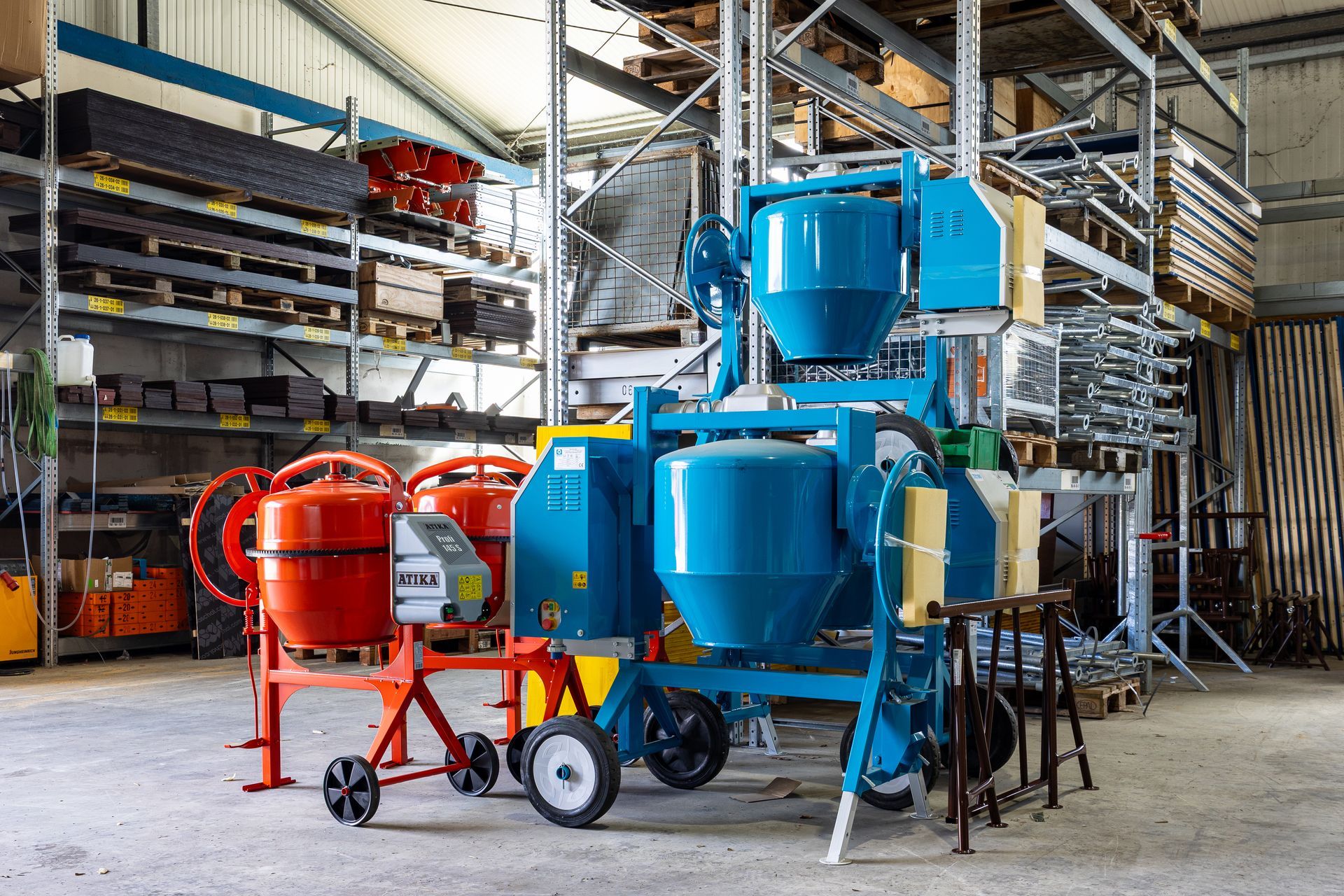 Industriehalle mit großen blauen und roten Maschinen auf fahrbaren Gestellen in einem Lagergang