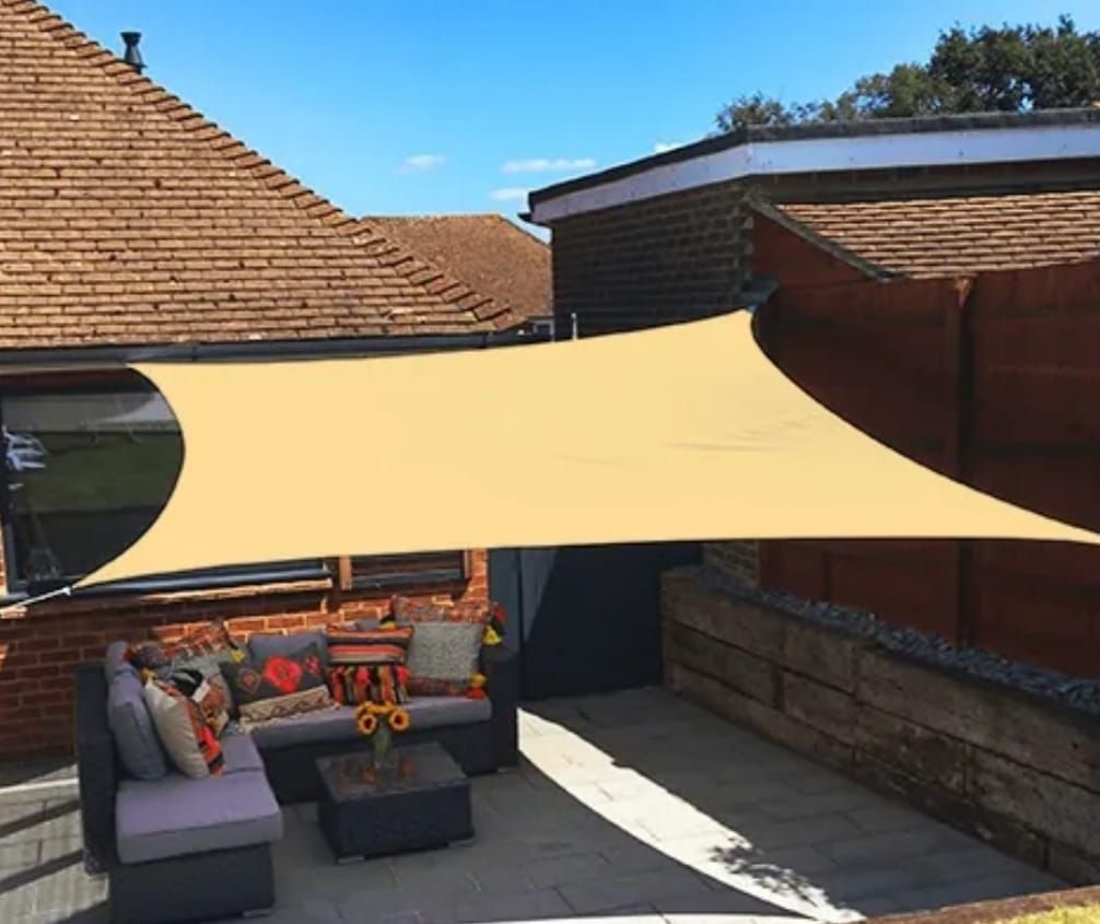 Un patio con un sofá y una mesa bajo una sombrilla.