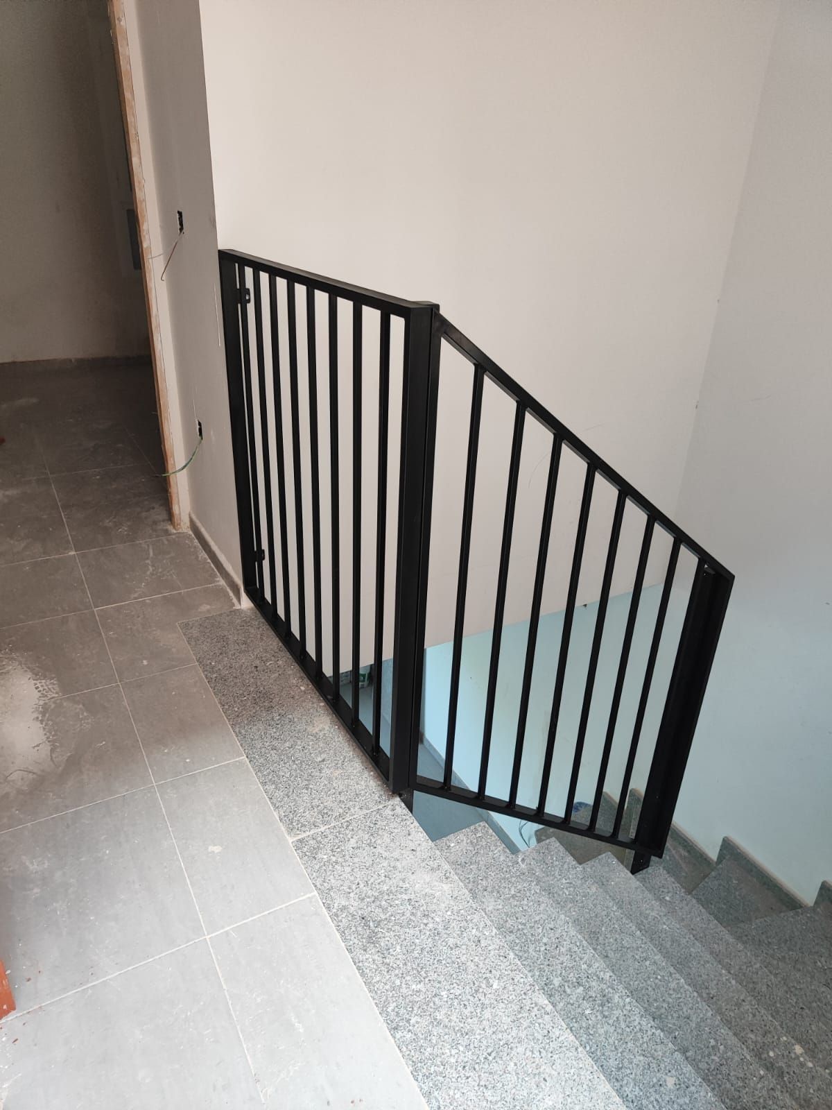 Una barandilla negra en un conjunto de escaleras de un edificio.