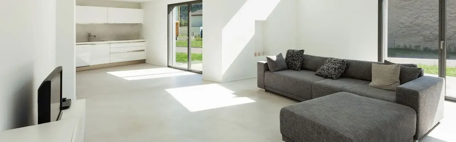 Una sala de estar con sofá, otomana y televisión.