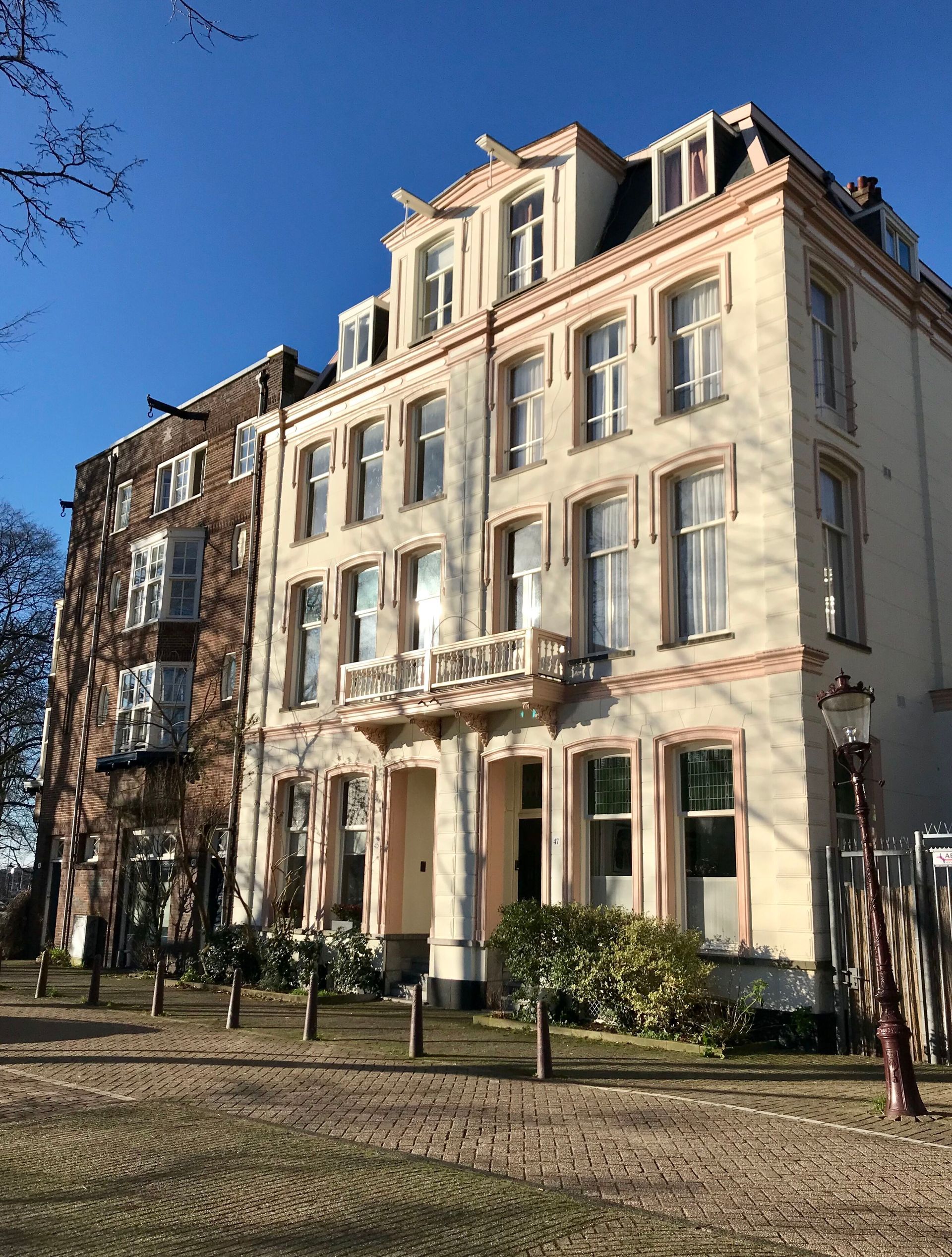 Spinoza Suites building with a lot of windows, white and pink colors