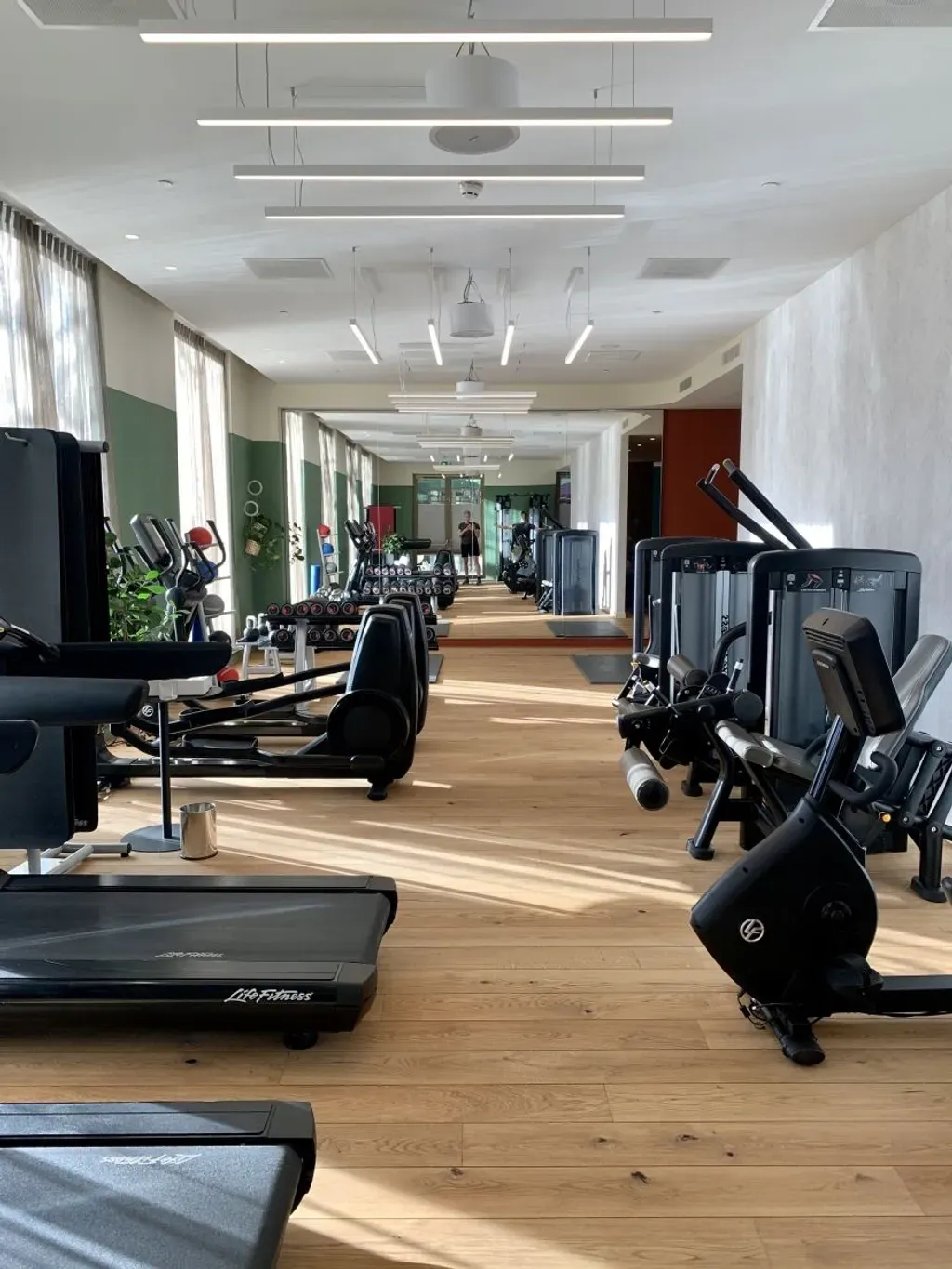 Gym in Hyatt Regency filled with treadmills , exercise bikes , and other exercise equipment.