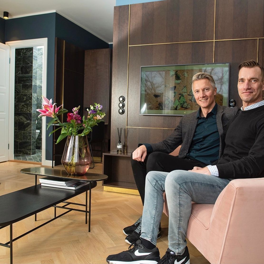 Owners are sitting on a couch in Canal Suite.