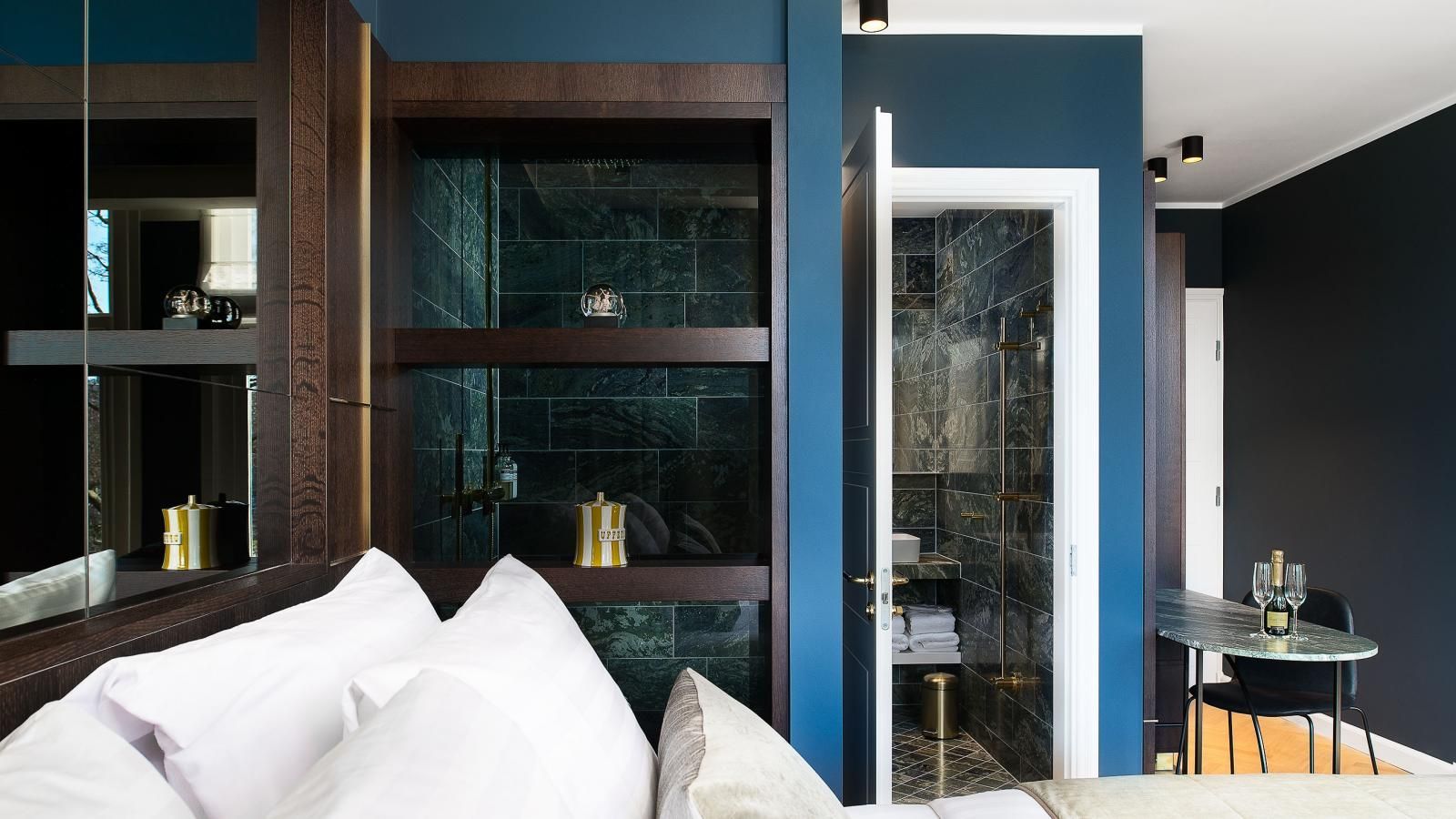 Canal Suite with blue walls , a bed , a table and a mirror.